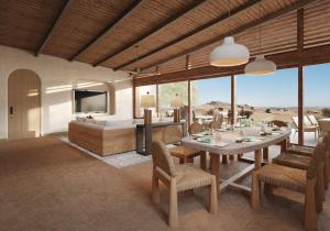 a living room with a table and chairs and a television at Six Senses Southern Dunes, The Red Sea 