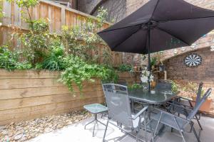 a table and chairs with an umbrella on a patio at 2 BD Apt with Large Courtyard near The Star Casino in Sydney
