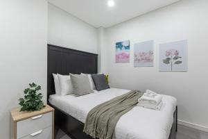 two beds in a bedroom with white walls at 2 BD Apt with Large Courtyard near The Star Casino in Sydney