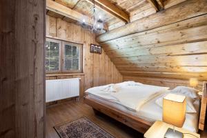 a wooden bedroom with a bed in a room at Chalet Durik Bystra-Jacuzzi-Sauna-Kids playground-Fire pit-Hiking in Horná Lehota