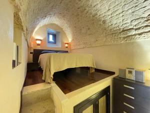 a bedroom with a bed in a room with a stone wall at Casa Vega in Ostuni