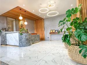 a lobby with a reception desk and potted plants at Metro Pines Inn in Baguio