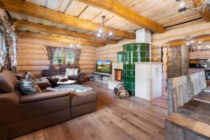 a living room with a couch and a fireplace in a log cabin at Chalet Durik Bystra-Jacuzzi-Sauna-Kids playground-Fire pit-Hiking in Horná Lehota