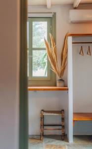 a room with a window and a stool at Houses at Chrisopigi Sifnos in Chrisopigi