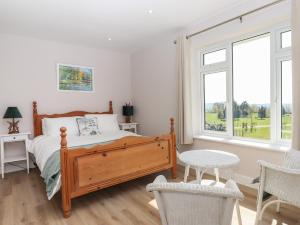 1 dormitorio con 1 cama, mesa y sillas en Hurdwick Lodge en Tavistock