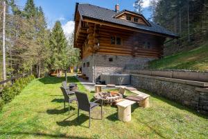 a backyard with a fire pit and a log cabin at Wellness Zrub Durik Bystra in Horná Lehota