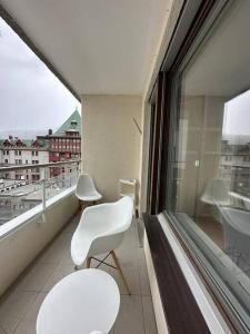 a balcony with two white chairs and a window at Appartamento centrale in St. Moritz