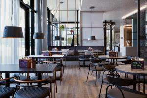 a restaurant with tables and chairs in a room at the niu Hub in Düsseldorf