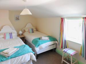 a small room with two beds and a window at West End Farmhouse in Barmston