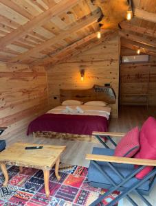 a bedroom in a log cabin with a bed and a table at Esinti Bungalows Otel in Çamlıhemşin