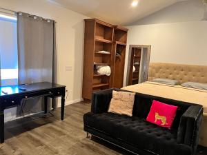a bedroom with a bed and a couch and a desk at condominiums in Los Angeles