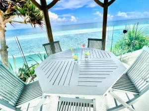 a table on the beach with chairs and the ocean at Domaine de la Falaise private villa in Souillac