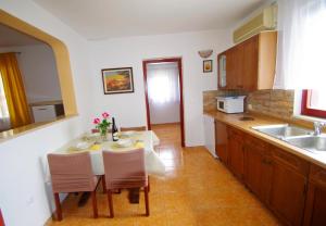 a kitchen with a table and chairs and a sink at Holiday apartment in village Dobrani in Rebići
