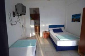 a small bedroom with a bed and a tv at Studio in Avşa Adası