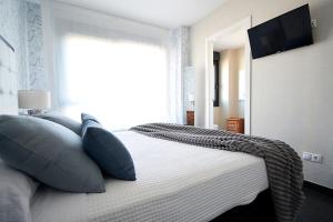 A bed or beds in a room at Apartamento con piscina en Portonovo, Sanxenxo