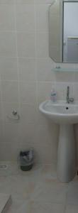 a white bathroom with a sink and a mirror at Studio in Avşa Adası