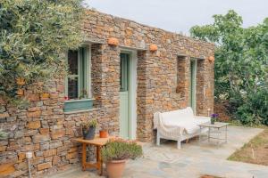 a stone building with a chair and a table at Houses at Chrisopigi Sifnos in Chrisopigi