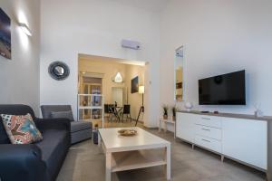 een woonkamer met een bank en een flatscreen-tv bij De' Villanova House in Brindisi