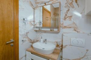 a white bathroom with a sink and a mirror at Lakeside Apartment in Palić +24 photos