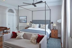 a bedroom with a canopy bed and a couch at Moonfleet Manor Hotel in Weymouth +58 photos