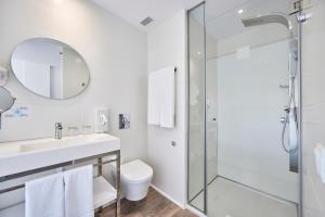 a white bathroom with a shower and a sink at Hotel Astoria Playa Adults Only 4* Sup in Port d'Alcudia