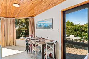 ein Esszimmer mit einem Tisch und Stühlen in der Unterkunft Lakehouse Retreat - Wanaka Holiday Home in Wanaka