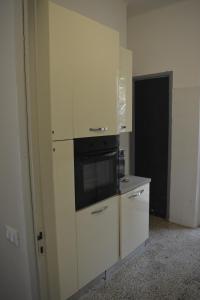 a kitchen with white cabinets and a microwave at La Terrazza su Portovenere in Portovenere