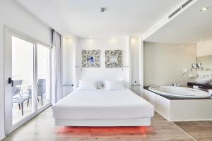 a white bedroom with a bed and a bath tub at Hotel Astoria Playa Adults Only 4* Sup in Port d'Alcudia