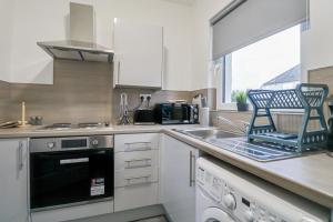 a kitchen with a sink and a stove top oven at Leadenflower Apartment in Crieff