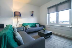 a living room with a couch and a window at Leadenflower Apartment in Crieff