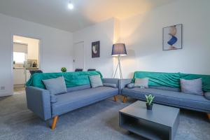 a living room with two couches and a table at Leadenflower Apartment in Crieff
