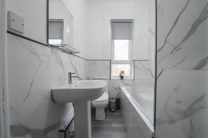 uma casa de banho com um lavatório, um WC e uma banheira em Leadenflower Apartment em Crieff