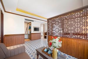ein Wohnzimmer mit einem Sofa und einem Tisch in der Unterkunft Hoi An Babylon Riverside Hotel & Spa in Hoi An