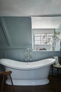 een badkamer met een wit bad en een raam bij Moonfleet Manor - A Luxury Family Hotel in Weymouth