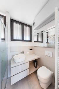 uma casa de banho branca com um WC e um lavatório em Nido sul lago-by Goccia di Lago em Desenzano del Garda