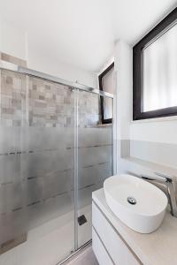 uma casa de banho com uma cabina de duche em vidro e um lavatório branco em Nido sul lago-by Goccia di Lago em Desenzano del Garda