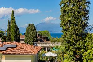 uma vista para uma casa com árvores e uma montanha em Nido sul lago-by Goccia di Lago em Desenzano del Garda