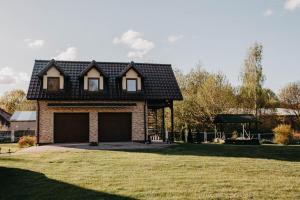 ein Haus mit einer Garage auf einem Grasfeld in der Unterkunft Rydzewo BRZOZOWA 9 in Rydzewo