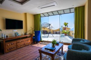 a living room with a flat screen tv and blue chairs at Aagantuk Resort in Banepa