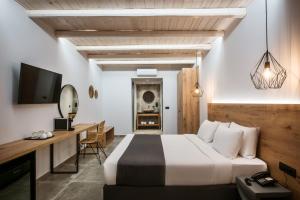 um quarto com uma cama, uma secretária e uma televisão em Casa Blu Boutique Hotel "by Checkin" Adults Only em Hersonissos