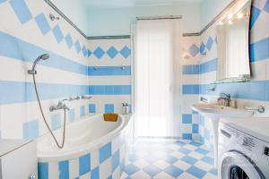 baño azul y blanco con bañera y lavamanos en Vintage Maisonette with 3-bdrms, Akti Elias Halkidiki, en Kalogria
