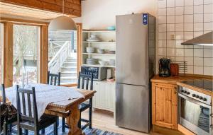 a kitchen with a table and a stainless steel refrigerator at Cozy Home In Ljuster With Kitchen in Norra Ljustero