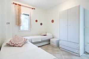 1 dormitorio con 2 camas y ventana en Vintage Maisonette with 3-bdrms, Akti Elias Halkidiki, en Kalogria