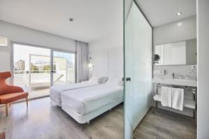 a white bedroom with a bed and a bathroom at Hotel Astoria Playa Adults Only 4* Sup in Port d'Alcudia