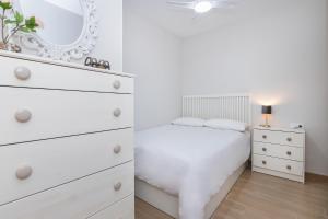 een witte slaapkamer met een witte dressoir en een spiegel bij BHost - Victoria 64 in Málaga