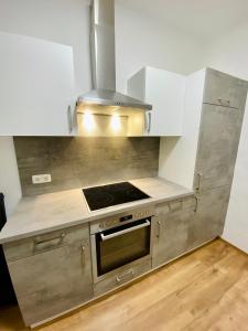 a kitchen with a stove and white cabinets at Rettenkogel im Zentrum von Bad Ischl in Bad Ischl