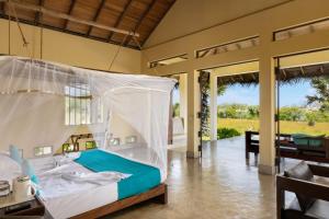 a bedroom with a bed with a mosquito net at Elements Beach & Nature Resort in Kalpitiya