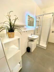 La salle de bains blanche est pourvue d'un lavabo et d'un miroir. dans l'établissement Rettenkogel im Zentrum von Bad Ischl, à Bad Ischl