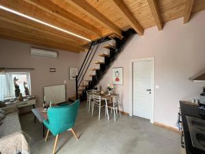 a living room with a staircase and a table and chairs at Attic View in Loutsa