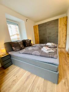 a bedroom with a large bed with a wooden floor at Siriuskogel im Zentrum von Bad Ischl in Bad Ischl